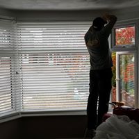 Paul fitting a blind in a living room